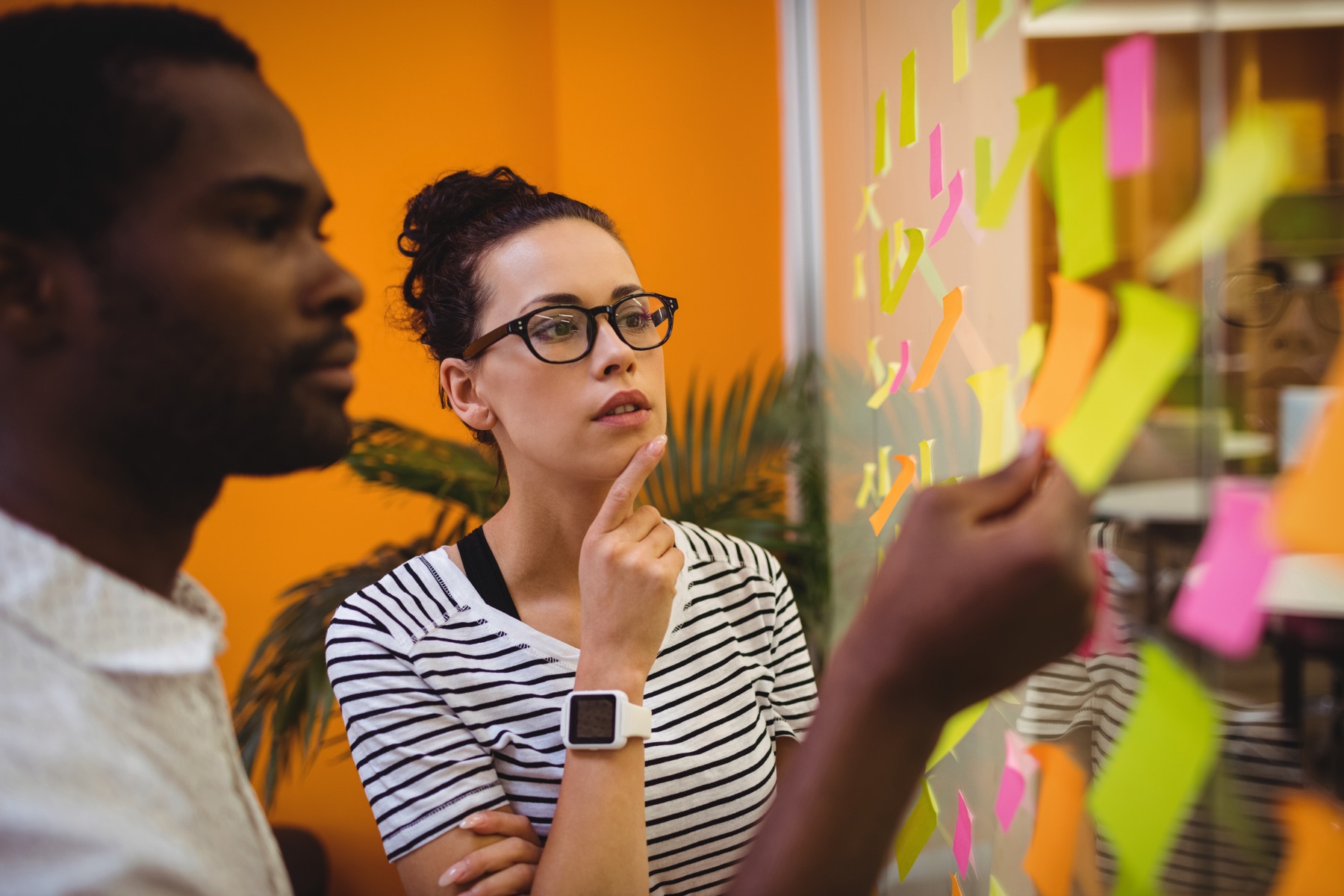A team reviewing ideas on a wall of sticky notes
